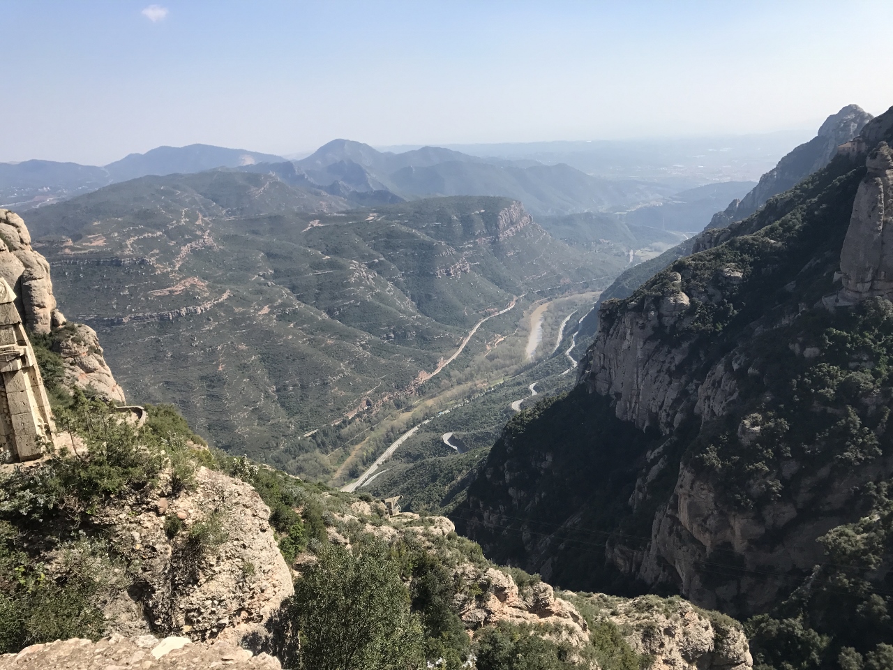 Rock faces with shrubbery and high mountain peaks that go as far as the eye can see